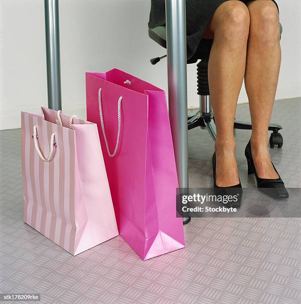 shopping bags lying next to woman's feet - next stockfoto's en -beelden