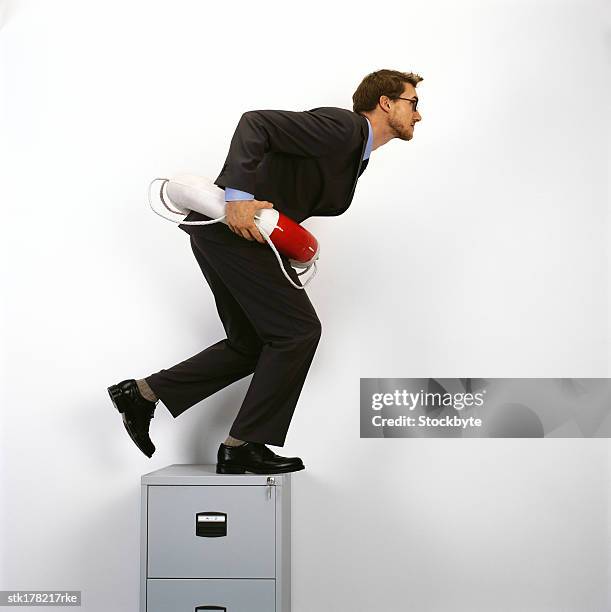 young man standing on top of a file cabinet wearing a life buoy - equipamento marítimo de segurança imagens e fotografias de stock