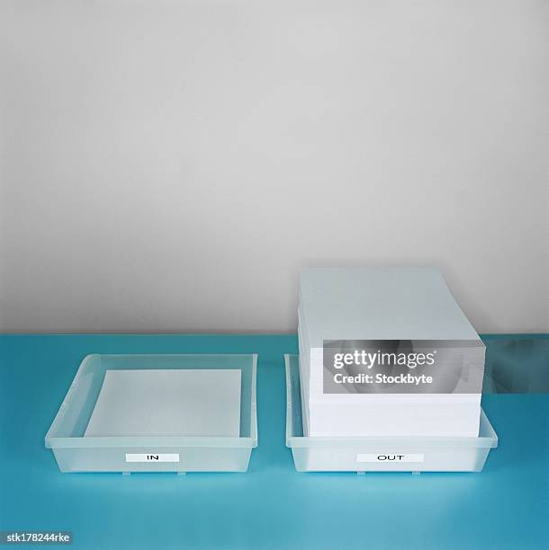 large stack of paper lying in an out tray - in out tray stock pictures, royalty-free photos & images