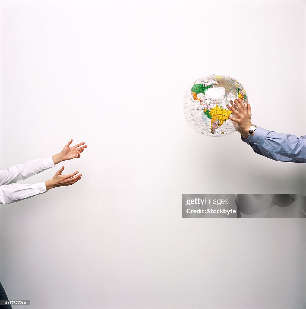 Person throwing a globe to another person