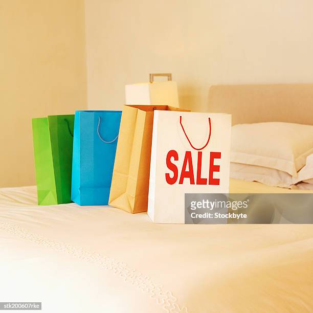 shopping bags on a bed and one bag with sale written on it - commercial event 個照片及圖片檔