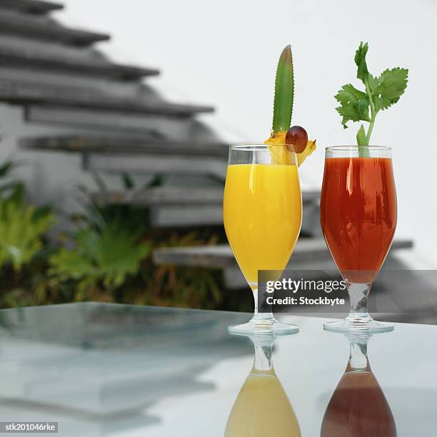 glass of orange juice and glass of tomato juice - tomato juice stock pictures, royalty-free photos & images