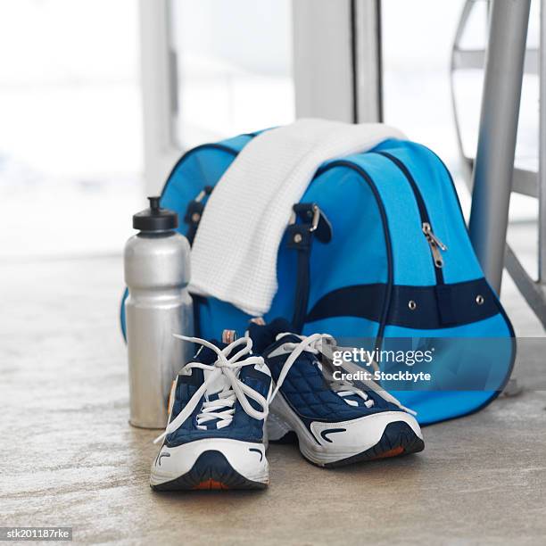 elevated view of sports bag and water bottle and running shoes and a towel - gym bag fotografías e imágenes de stock