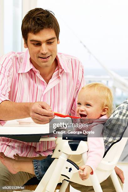 father feeding his baby daughter (12-18 months) - genderblend stock-fotos und bilder