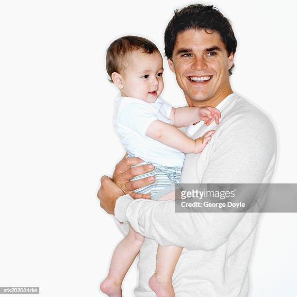 father holding baby son (12-18 months) - genderblend stock-fotos und bilder