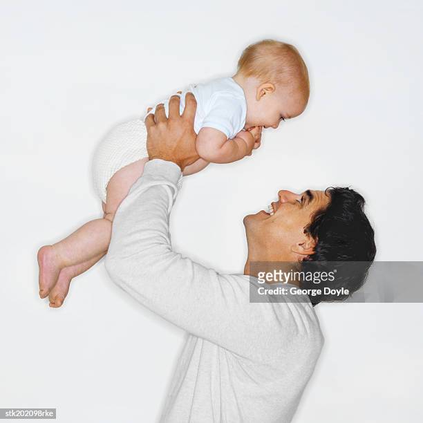 side view of a father playing with his baby son (6-12 months) - genderblend stock pictures, royalty-free photos & images