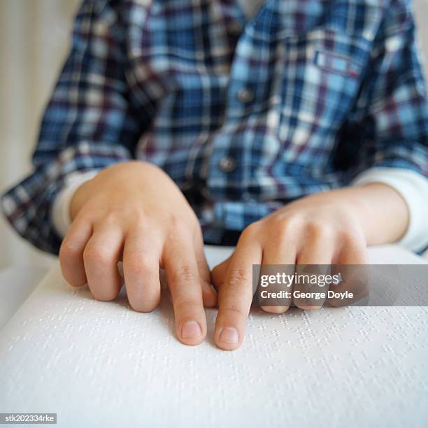 close up view of the mid section of a person reading by braille - kid middle finger stock-fotos und bilder