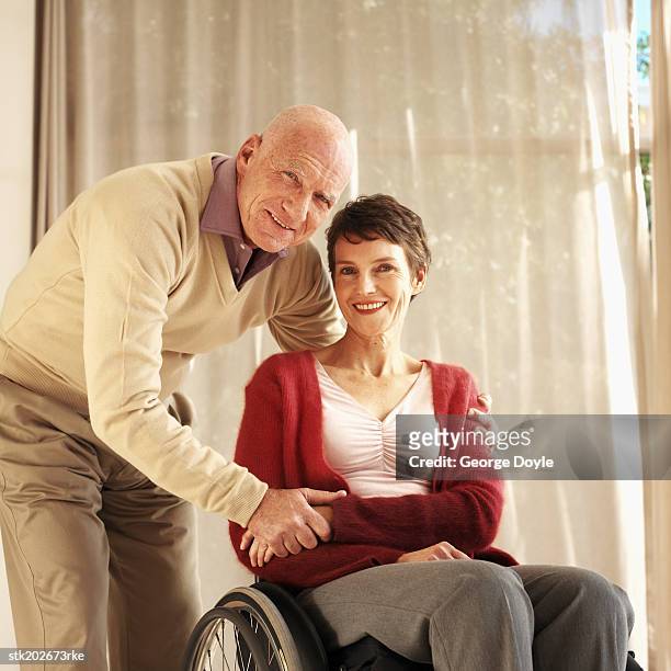 portrait of a husband and his wife who is sitting in a wheelchair - is stock pictures, royalty-free photos & images