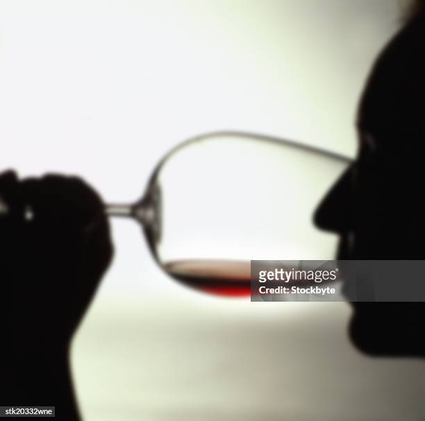 silhouette of a person drinking red wine - taste of john paul ataker presentation spring 2016 new york fashion week stockfoto's en -beelden