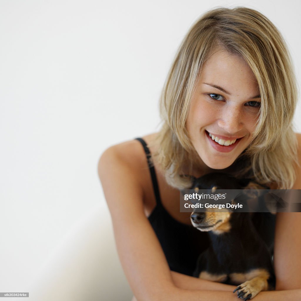 Close up portrait of a woman holding her English toy terrier