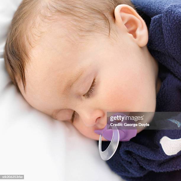 elevated close up view of a baby (6-12 months) sleeping with a dummy in its mouth - only baby boys stock pictures, royalty-free photos & images