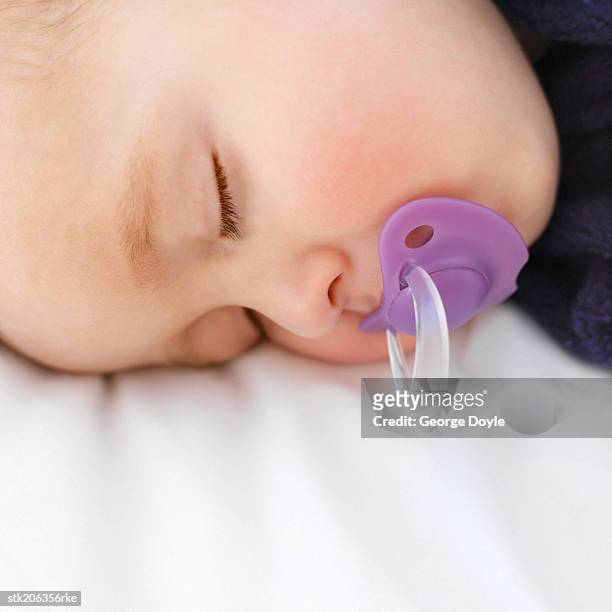 elevated close up view of a baby (6-12 months) sleeping with a dummy in its mouth - only baby boys stock pictures, royalty-free photos & images