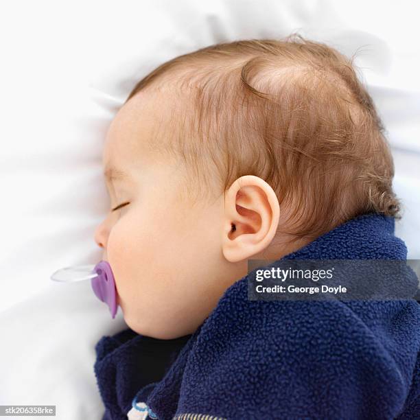 elevated close up view of a baby (6-12 months) sleeping with a dummy in its mouth - only baby boys stock pictures, royalty-free photos & images