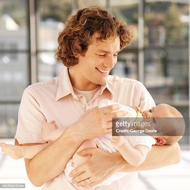 father bottle feeding baby (6-12 months) - intergénero fotografías e imágenes de stock