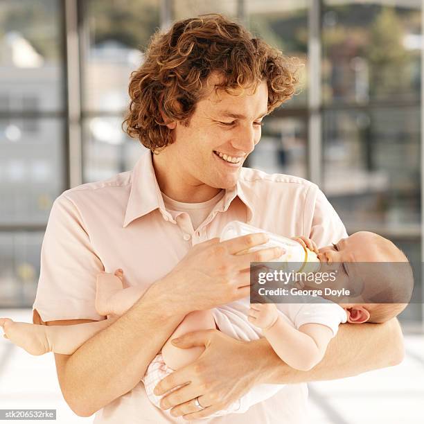 father bottle feeding baby (6-12 months) - genderblend stock pictures, royalty-free photos & images