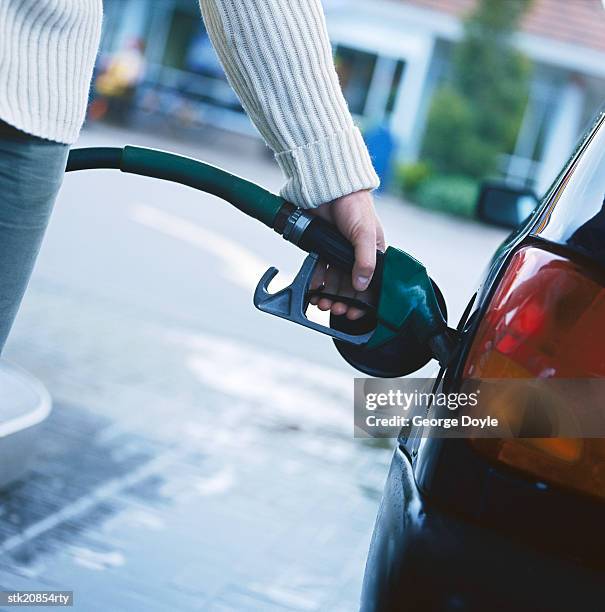 person filling petrol in a car gas tank - abad stock pictures, royalty-free photos & images