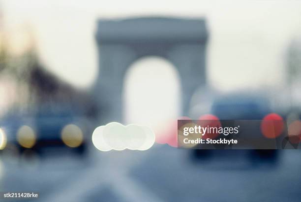 blurred view of the arc de triomphe and champs elysee, paris - elysee stock pictures, royalty-free photos & images