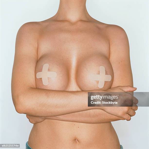 mid section view of a nude woman with plasters over her nipples - aumento dos seios imagens e fotografias de stock