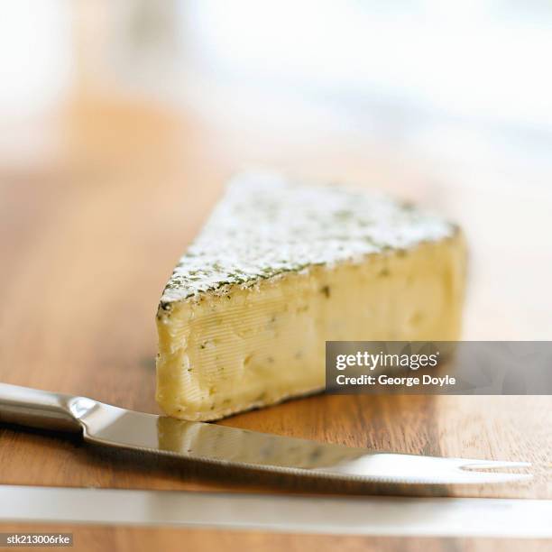 close up view of a wedge of cheese and a cheese knife - cheese wedge foto e immagini stock