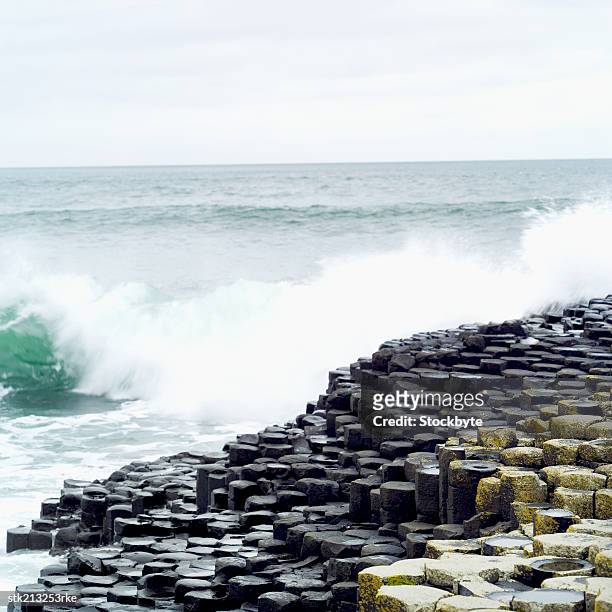 two people standing on the giants causeway in county antrim - column stock pictures, royalty-free photos & images