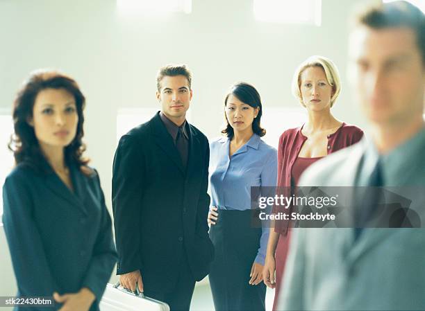 close-up of a businessman standing ahead of his co-workers (blurred) - get ahead stock-fotos und bilder