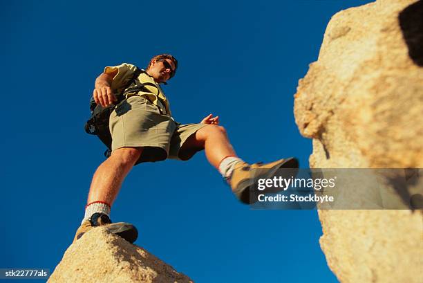 low angle view of a man hiking over rocks - national archives foundation honor tom hanks at records of achievement award gala stockfoto's en -beelden