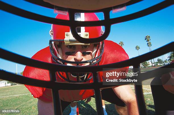 view of the opponent through a football helmet - casque de football américain photos et images de collection
