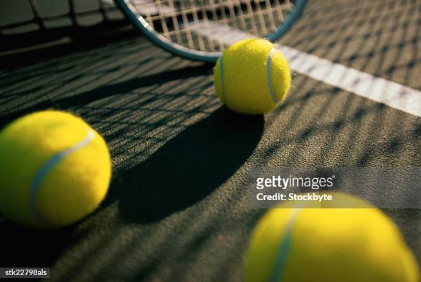 low angle view of tennis balls and a racket on a tennis court - tennis court stock pictures, royalty-free photos & images
