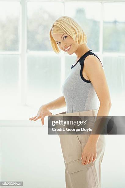 side view of a satisfied woman stretching the waistband of her pants - waistband 個照片及圖片檔