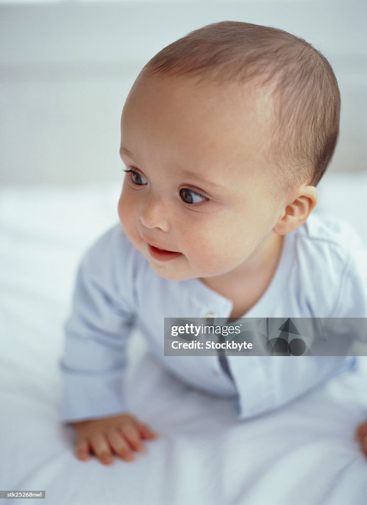 Close up of a baby crawling on a bed