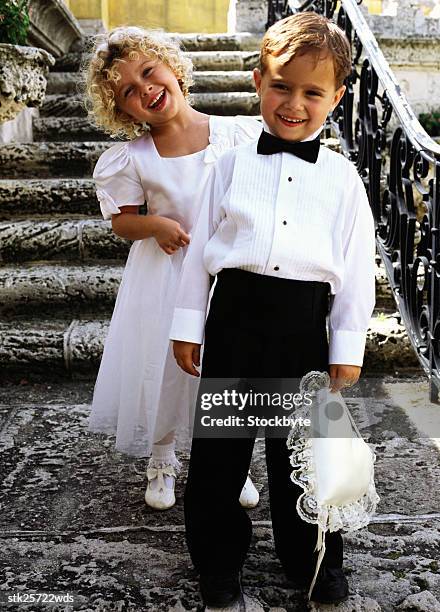 portrait of a ring bearer (6) and a bridesmaid (6) standing on the steps - ring bearer stockfoto's en -beelden