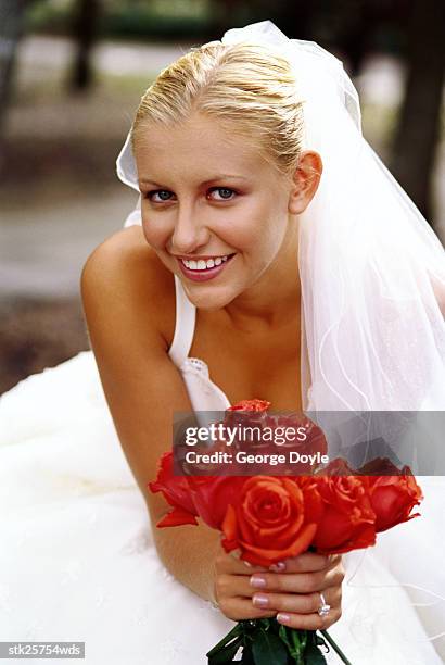 portrait of a bride holding a bunch of red roses - rosaceae stock-fotos und bilder