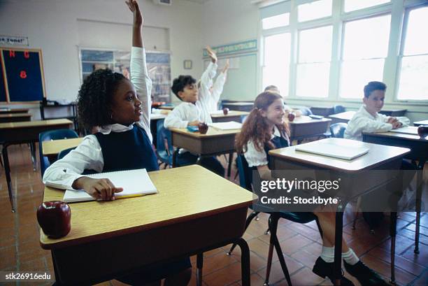 portrait of students (8-10) raising their hands to answer in class - donald trump holds campaign rally in nc one day ahead of primary stockfoto's en -beelden