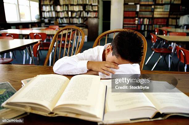 portrait of a boy (8-10) asleep on a library table - donald trump holds campaign rally in nc one day ahead of primary stockfoto's en -beelden
