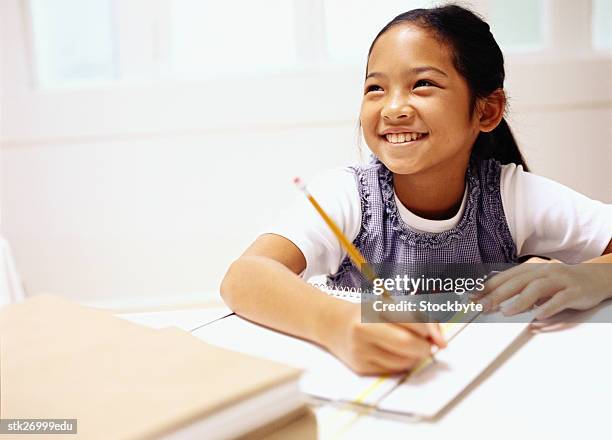 portrait of a girl (8-10) smiling and writing in class - donald trump holds campaign rally in nc one day ahead of primary stockfoto's en -beelden