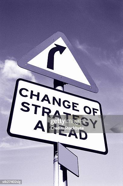 black and white low angle view of a road sign saying change of strategy ahead - get ahead stock-fotos und bilder