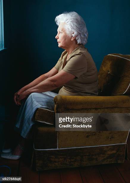 side profile of an elderly woman sitting on chair looking out the window - richard grieco hosts opening night gala for his one man art exhibit sanctum of a dreamer stockfoto's en -beelden