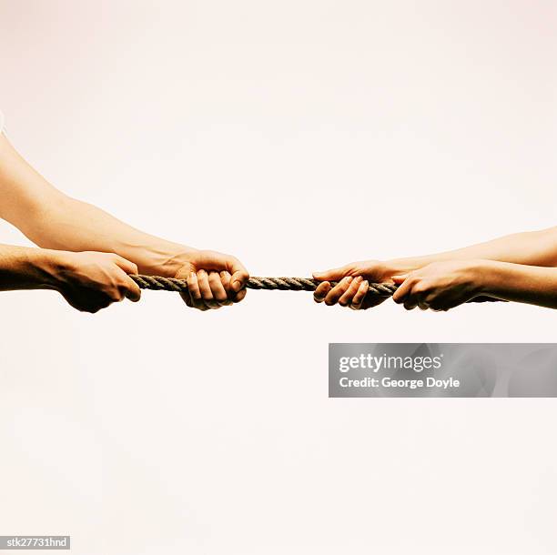 close-up of hands tugging at a rope - george nader stockfoto's en -beelden