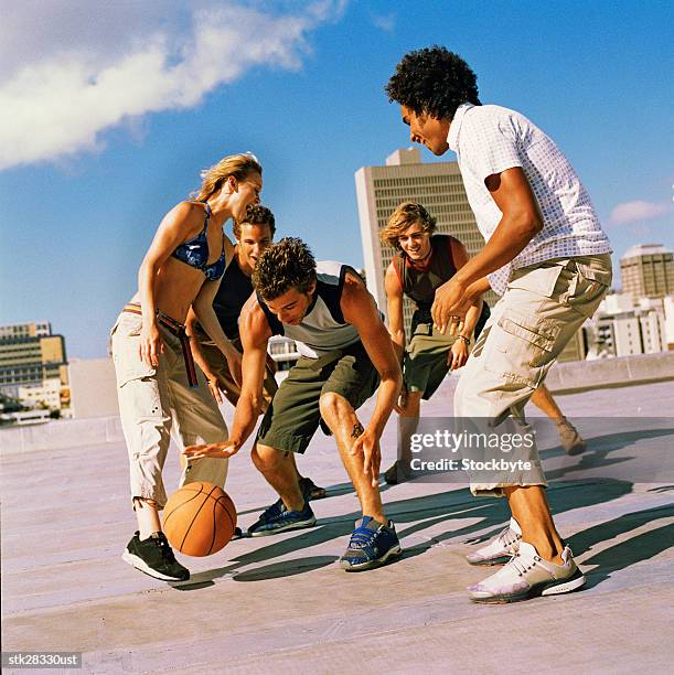 low angle view of a group of youths playing basketball - woman yellow basketball stock pictures, royalty-free photos & images