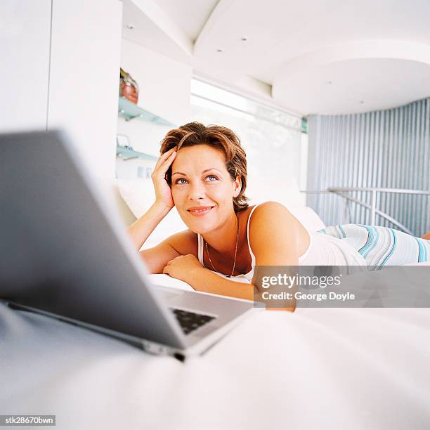 close-up of a woman lying in bed daydreaming with a laptop computer in front of her - richard grieco hosts opening night gala for his one man art exhibit sanctum of a dreamer stockfoto's en -beelden