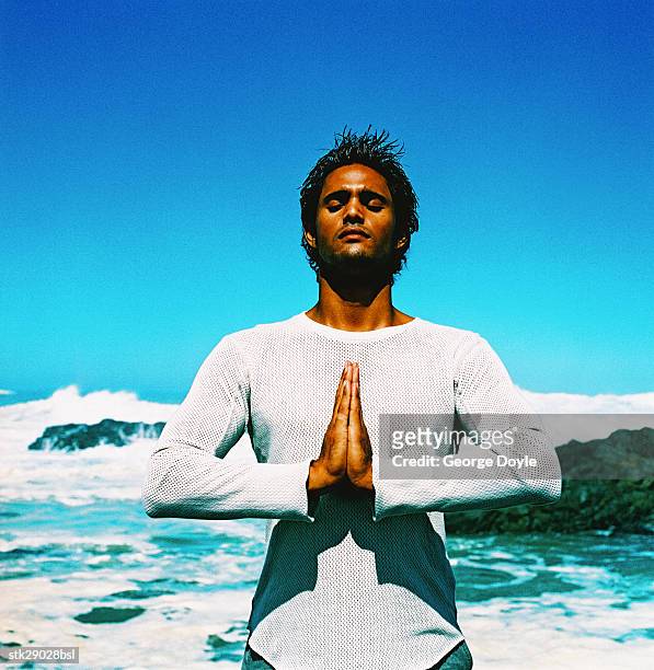 view of a young man doing yoga at the beach - duing stock pictures, royalty-free photos & images