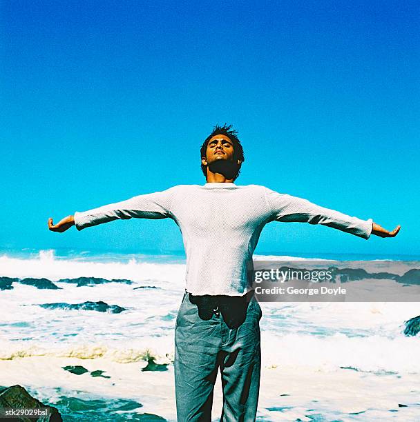 view of a young man doing yoga at the beach - duing stock pictures, royalty-free photos & images