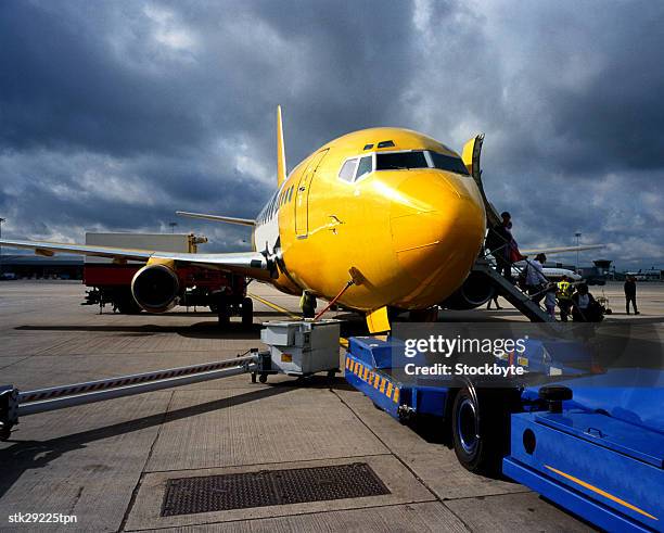 view of the front of an aircraft being refueled at an airport - open roads world premiere of mothers day arrivals stockfoto's en -beelden