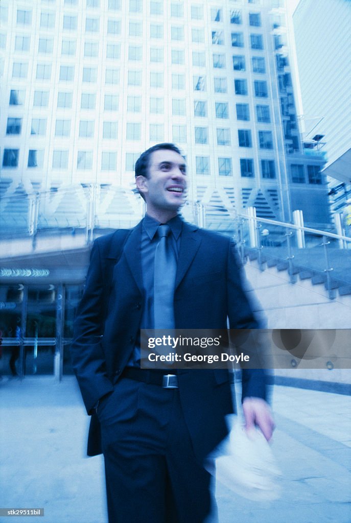 Businessman walking outdoors (blurred)