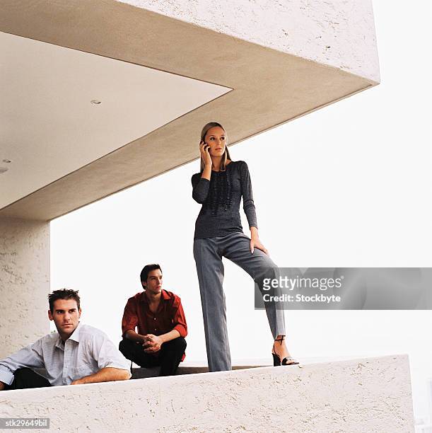 low angle view of two men and a woman together on a balcony - leading edge stock pictures, royalty-free photos & images