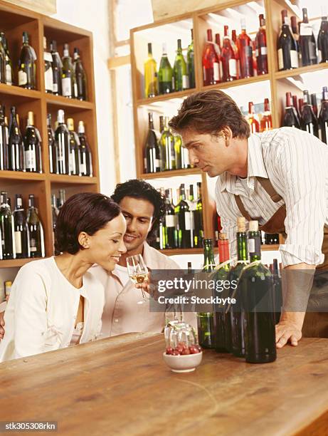 young woman sniffing a glass of white wine in a liquor store - tony curtis in person at the film forum to present screenings of sweet smell stockfoto's en -beelden