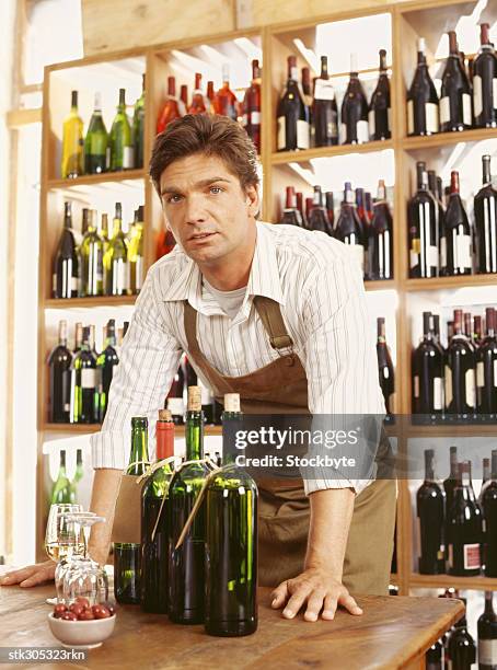 portrait of a mid adult man standing in a liquor store - liquor stockfoto's en -beelden