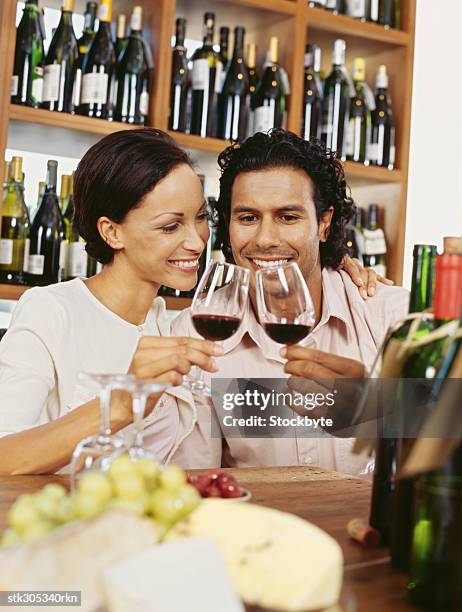 young couple toasting wine in a liquor store - liquor stockfoto's en -beelden