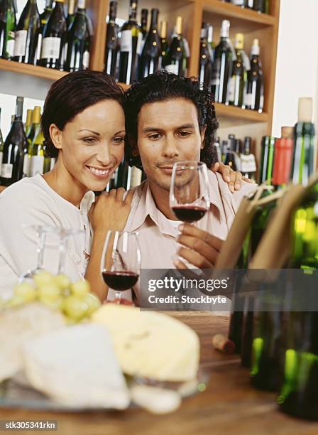 young couple sitting in a liquor store - liquor stockfoto's en -beelden