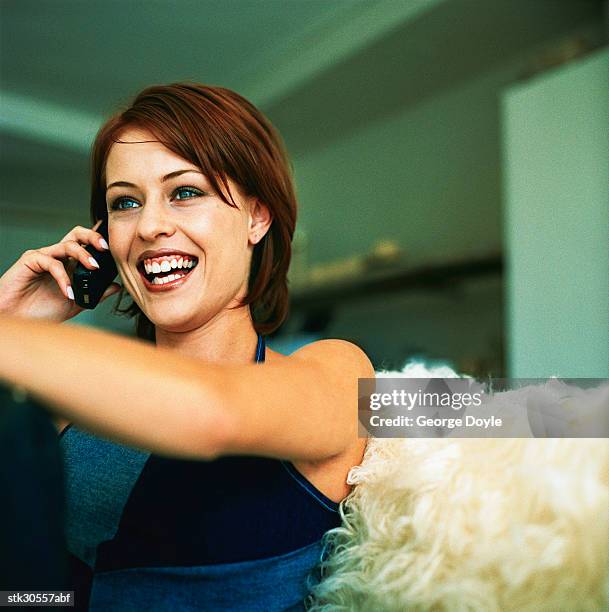 woman using a mobile phone and laughing - cross-entwicklung stock-fotos und bilder